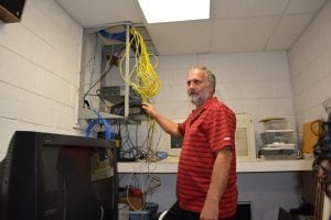 Superintendent, Bruce Shelley looking at network equipment