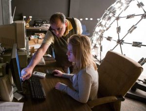 Teacher with student using computer