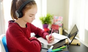 Preteen girl working on homework using tablet